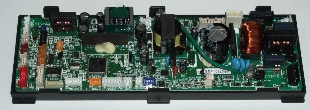 Grüne Platine mit verschiedenen elektronischen Komponenten, darunter ein Transformator, Kondensatoren und Terminals, eingebaut in ein schwarzes Gehäuse, möglicherweise für Daikin-Geräte.